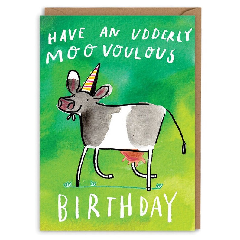 Op de afbeelding: Een groene verjaardagskaart met een cartoonkoe die een feestmuts draagt. De kaart zegt "Have an udderly moo-vellous birthday".