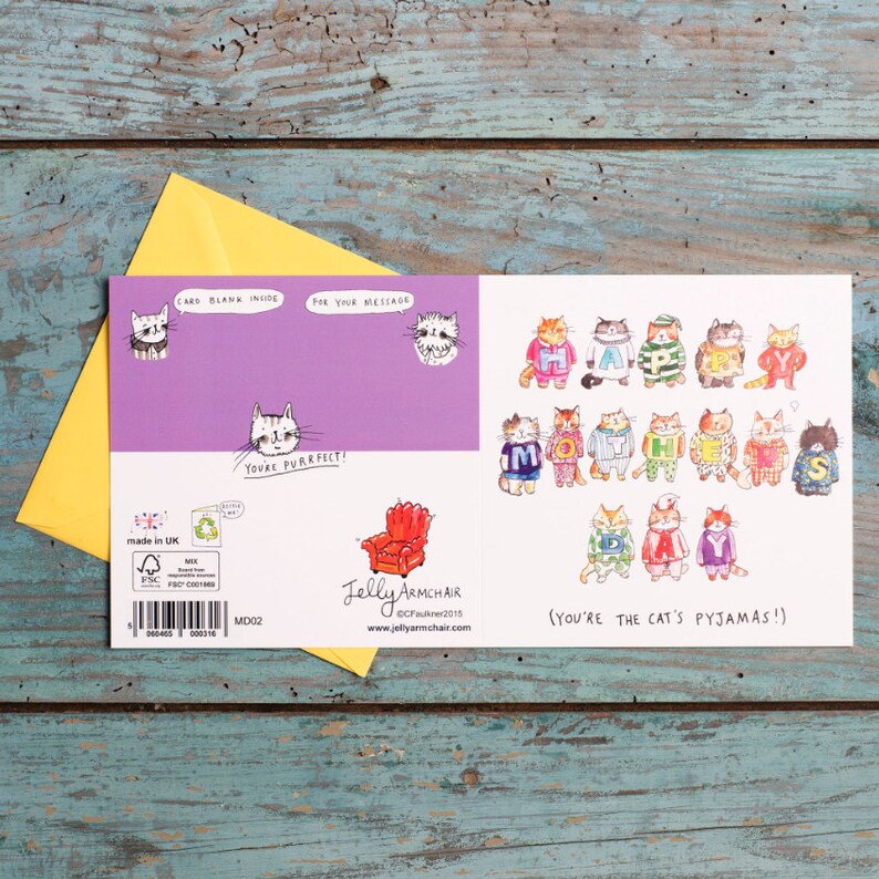 Puede incluir: Una tarjeta de felicitaci&oacute;n con un fondo morado y un mensaje que dice "You're purrfect!" La parte delantera de la tarjeta presenta una ilustraci&oacute;n colorida de gatos con pijamas que forman las palabras "Happy Mother's Day". El texto "(You're the cat's pajamas!)" est&aacute; impreso debajo de la ilustraci&oacute;n.
