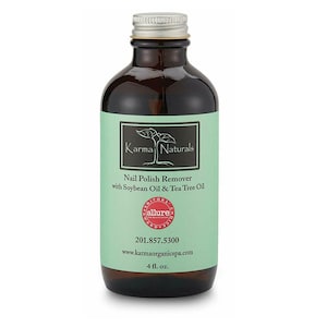 May include: A brown glass bottle with a silver lid containing Karma Naturals Nail Polish Remover with Soybean Oil & Tea Tree Oil. The bottle is labelled with the product name, ingredients, and website address. The bottle is 4 fluid ounces.