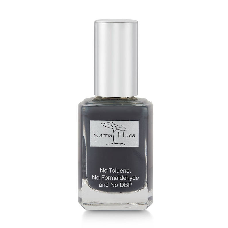 May include: A dark gray nail polish bottle with a silver cap. The bottle has a label that says "Karma Hues" and "No Toluene, No Formaldehyde and No DBP".