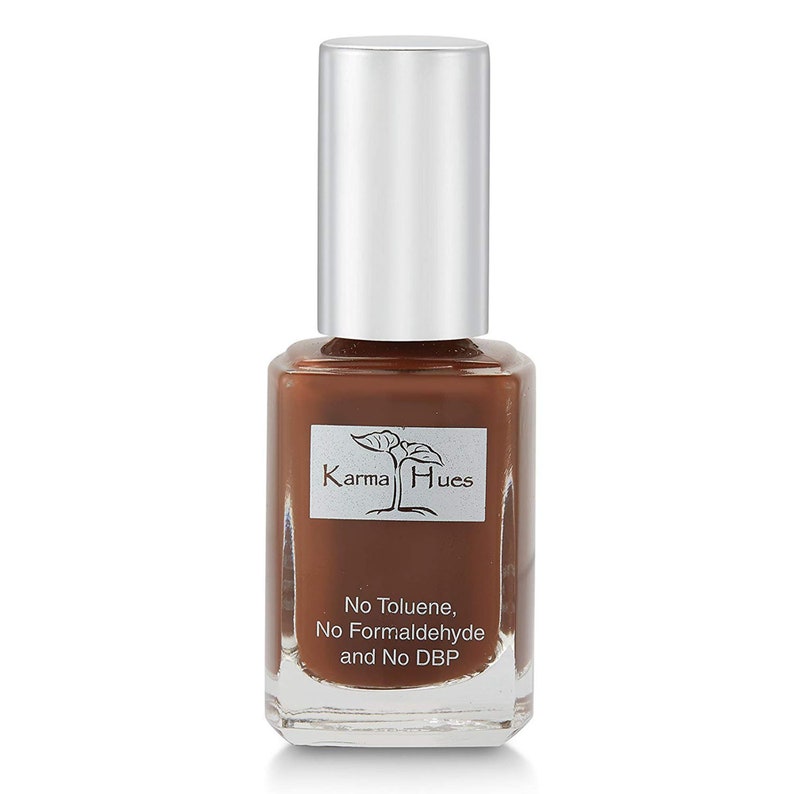 May include: A brown nail polish bottle with a silver cap. The bottle has a label that says "Karma Hues" and "No Toluene, No Formaldehyde and No DBP".