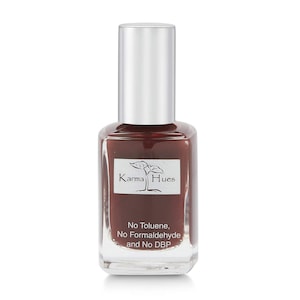 May include: A bottle of Karma Hues nail polish in a deep burgundy red color. The bottle is labeled with the brand name and the words "No Toluene, No Formaldehyde and No DBP".
