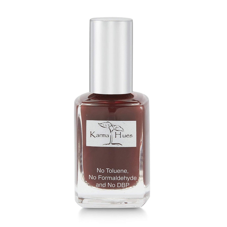 May include: A bottle of Karma Hues nail polish in a deep burgundy red color. The bottle is labeled with the brand name and the words "No Toluene, No Formaldehyde and No DBP".