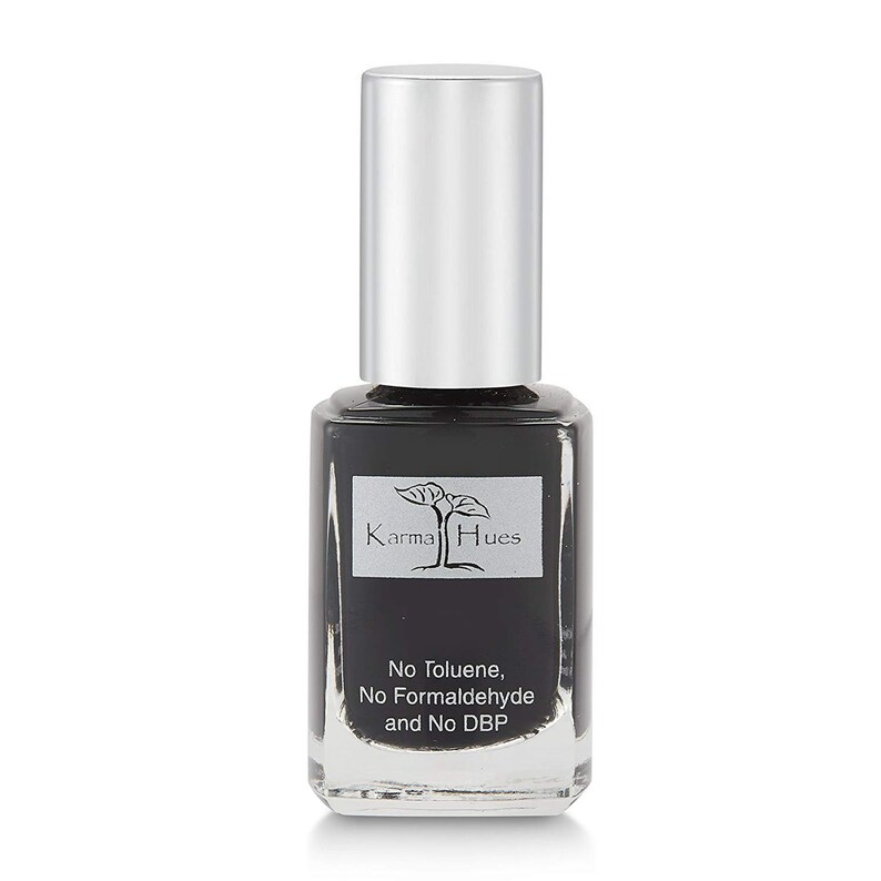 May include: A black nail polish bottle with a silver cap. The bottle has a label that says "Karma Hues" and "No Toluene, No Formaldehyde and No DBP".
