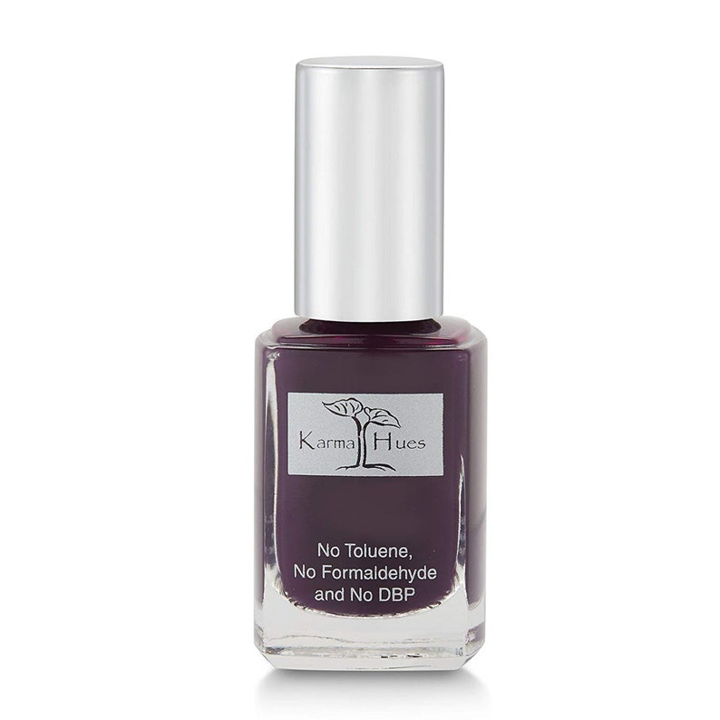 May include: A bottle of Karma Hues nail polish in a deep purple shade. The bottle is labeled with the brand name and the words "No Toluene, No Formaldehyde and No DBP".