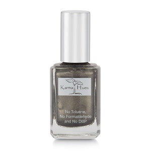 May include: A bottle of Karma Hues nail polish in a metallic silver color. The bottle is clear glass with a silver cap. The label says "Karma Hues" and "No Toluene, No Formaldehyde and No DBP".