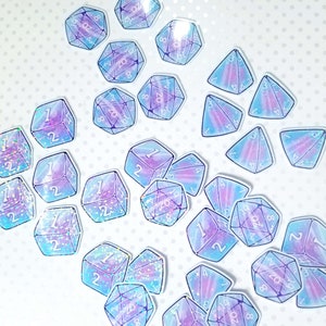 May include: A collection of iridescent holographic stickers featuring various dice with different numbers. The dice are in shades of blue and purple with glitter accents.