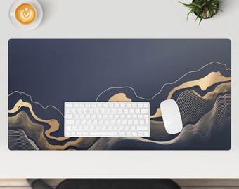 May include: A dark blue desk mat with a gold abstract design. A white keyboard and mouse are on the mat.