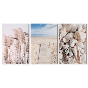 Puede incluir: Un tríptico de impresiones artísticas en lienzo con escenas de playa. Una impresión muestra hierba de la pampa. Otra representa un paseo marítimo de madera que conduce al océano. La tercera muestra una colección de conchas marinas.