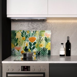 Puede incluir: Un protector de salpicaduras de cocina floral de colores con un esquema de colores verde, amarillo y naranja. El protector de salpicaduras está instalado detrás de una placa de cocción con una olla en el quemador.