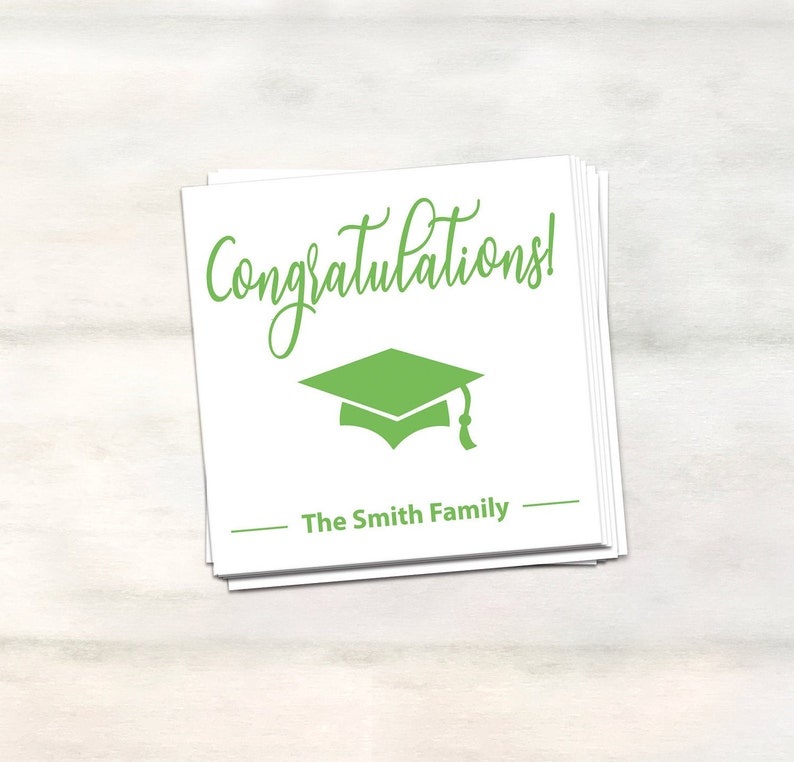 Puede incluir: Tarjeta blanca con texto verde que dice "&iexcl;Felicidades!" y un gorro de graduaci&oacute;n verde. La tarjeta tambi&eacute;n tiene el texto "The Smith Family" en negro.