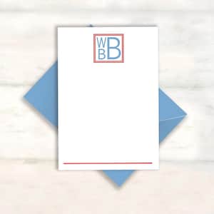 May include: A white rectangular stationery card featuring a light blue monogram with the letters WB and B enclosed in a red square border. A thin red horizontal line is printed at the bottom of the card, which rests on a light blue envelope.
