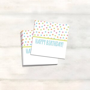 Peut inclure: Une pile de cartes de v&oelig;ux vierges avec un motif de pois multicolores et le texte "Happy Birthday!" sur la carte du dessus.