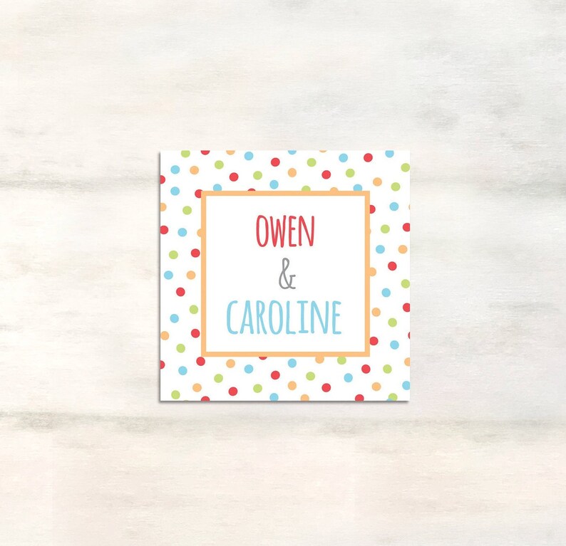 Puede incluir: Una tarjeta blanca con un patr&oacute;n de lunares de colores. La tarjeta tiene un borde rojo y el texto "Owen & Caroline" en el centro.