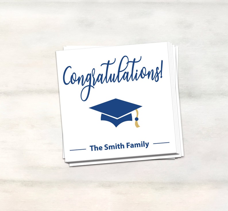 Puede incluir: Tarjeta blanca con texto azul y dorado que dice "&iexcl;Felicidades!" con un icono de gorro de graduaci&oacute;n azul y el texto "The Smith Family" en negro.