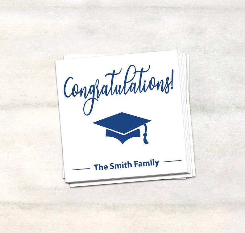 Puede incluir: Tarjeta blanca con texto azul que dice "&iexcl;Felicidades!" y un gorro de graduaci&oacute;n azul. La tarjeta tambi&eacute;n tiene el texto "The Smith Family" en azul.