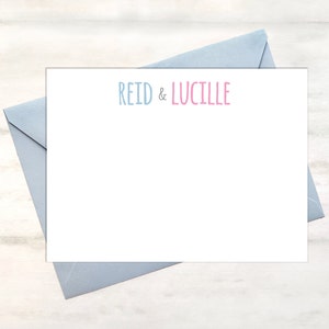 May include: A white card with a blue envelope. The card has the text "REID & LUCILLE" in blue and pink lettering.