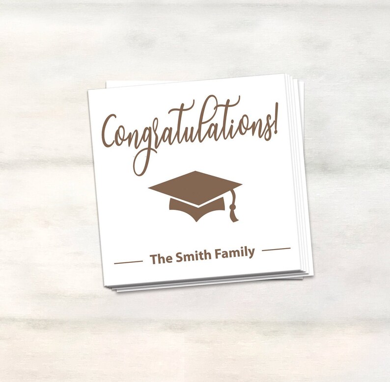 Puede incluir: Tarjeta blanca con texto marr&oacute;n que dice "&iexcl;Felicidades!" y un icono de gorro de graduaci&oacute;n marr&oacute;n. Debajo del texto hay una l&iacute;nea que dice "The Smith Family".