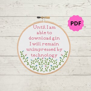 Könnte beinhalten: Ein weißer Stickrahmen mit einem rosa und grünen Kreuzstich-Design. Das Design lautet "Until I am able to download gin I will remain unimpressed by technology".