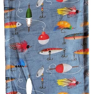Op de afbeelding: Een blauw stoffen etui met een herhalend patroon van vislokazen, dobbers en haken. De lokazen zijn in verschillende kleuren, waaronder rood, geel en zilver. De etui heeft een witte rits en een gestikte rand.
