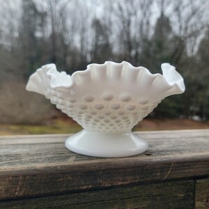 Può includere: Una tazza di ceramica bianca con manico nero e la scritta "But First, Coffee" in nero, in grassetto. La tazza è su una superficie bianca.