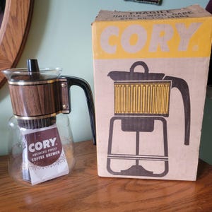 Puede incluir: Un juego de tres cuencos de cerámica apilables de tamaños graduados. Los cuencos presentan un esmalte moteado blanquecino con una superficie ligeramente texturizada. El cuenco más grande tiene aproximadamente 20 cm de diámetro.