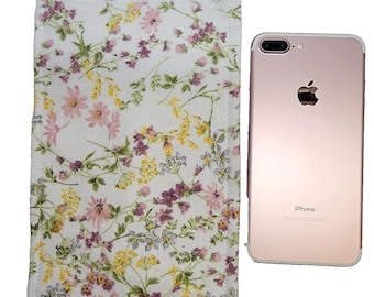 May include: A white fabric phone case with a floral pattern in shades of pink, yellow, and purple. The case has a velcro closure and is shown next to a rose gold iPhone.