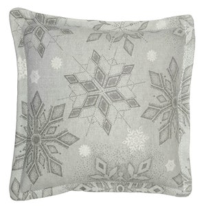 Puede incluir: Una almohada gris con un patrón de copo de nieve. Los copos de nieve son en tonos de gris y blanco.