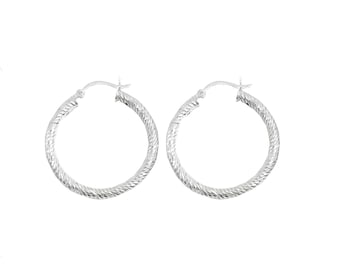 May include: A pair of silver hoop earrings with a textured, braided design.