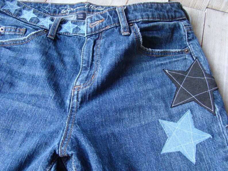 May include: Blue denim jeans with a black and a blue star patch sewn on the back pockets.