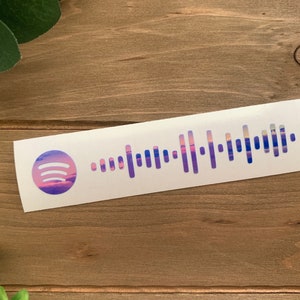 May include: A white sticker with a purple and pink sunset-themed Spotify code. The code is surrounded by a white border.