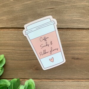 May include: A sticker of a coffee cup with the text "Coffee, Scrubs & Rubber Gloves" and a small pink heart.