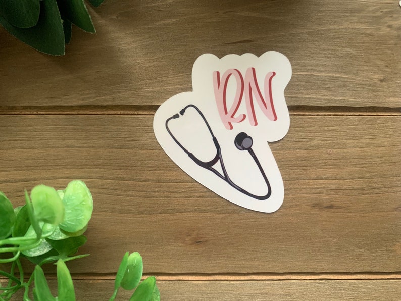 May include: A white sticker with a black stethoscope and the word "RN" in pink lettering.