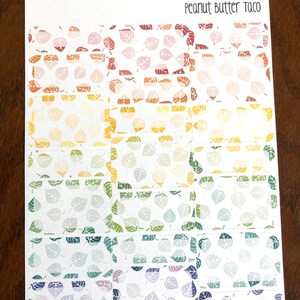 May include: A sheet of colorful leaf patterned stickers with the text "Peanut Butter Taco" at the top. The stickers are arranged in rows of 4, with each row featuring a different color gradient.