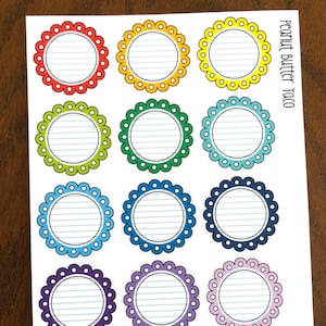 May include: A sheet of 12 colorful round stickers with a scalloped edge. Each sticker has a white center with blue lines and a blank space for writing. The text "Peanut Butter Taco" is printed in the top right corner.