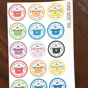 May include: Sheet of circular stickers with a cartoon slow cooker design in various colors, including red, orange, yellow, green, blue, purple, pink, and black. Each sticker has the text "Rock out with your crock!" around the edge.