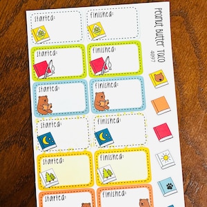 May include: A sticker sheet labeled Peanut Butter Taco 4097 featuring rectangular labels with the text started or finished. The labels include colorful illustrations of books, bears, fishing rods, trees, moons, and suns in various border colors.
