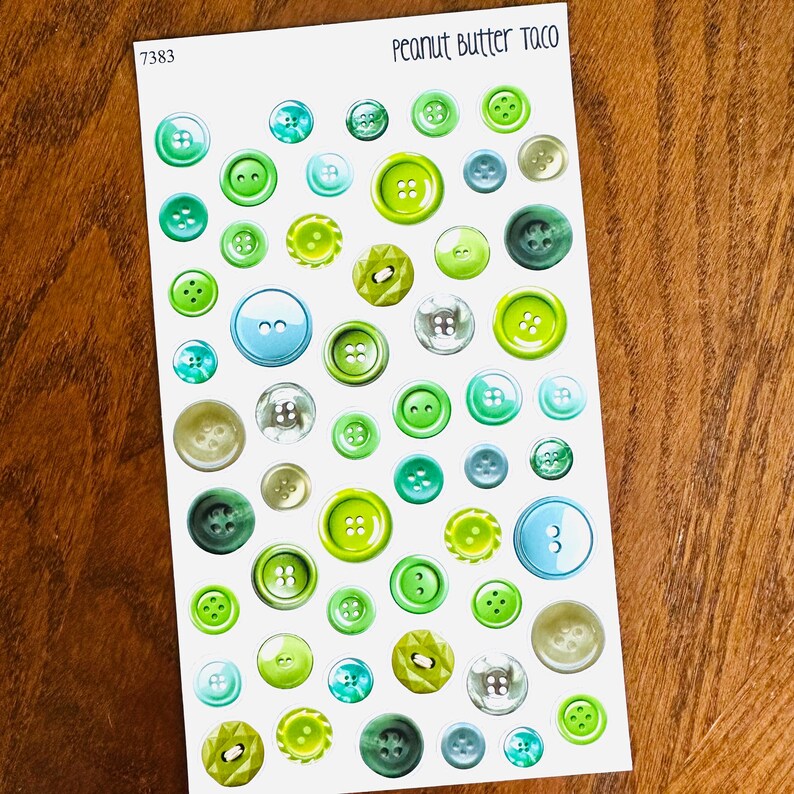 May include: A sheet of stickers featuring various sizes of green, blue, and clear buttons. The text "Peanut Butter Taco" is at the top, and the number "7383" is in the upper left corner.