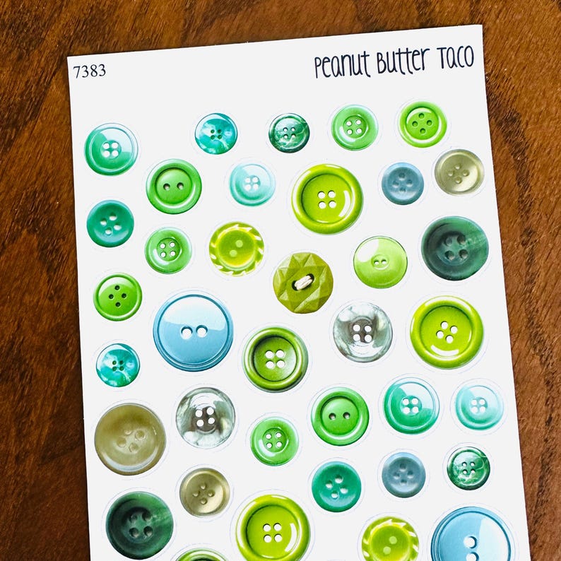 May include: A sheet of stickers featuring various green, blue, and clear buttons. The buttons vary in size and design, with some having two or four holes. The text "Peanut Butter Taco" is at the top right, and "7383" is in the top left.