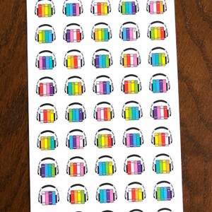 May include: A sheet of 40 colorful stickers featuring a stack of books with headphones on top. The text "Peanut Butter Taco" is at the top of the sheet.
