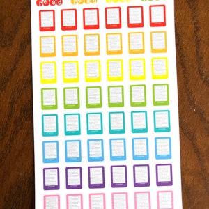 May include: A sheet of colorful book-shaped stickers with the text "read" in white letters on a red background. The stickers are arranged in rows and columns, with each row featuring a different color. The colors are red, orange, yellow, green, blue, purple, and pink. The sheet is labeled "Peanut Butter Taco" at the top.