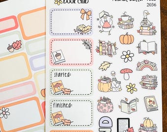 May include: Two sheets of planner stickers with a book club theme. One sheet has blank rectangular labels with floral and acorn accents. The other sheet has various illustrations of books, pumpkins, and fall-themed elements.