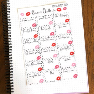 May include: A white sheet of paper with black hearts and red lips printed on it. The paper is divided into squares with text in each square. The text includes "Romance Challenge", "couple on cover", "second chance", "fake relationship", "friends to lovers", "love triangle", "slow burn", "includes a wedding", "red or pink cover", "forbidden love", "best friend's sibling", "enemies to lovers", "stick together", "return to hometown", "athlete", "instalove", "unrequited love", "fling", and "heart on cover".