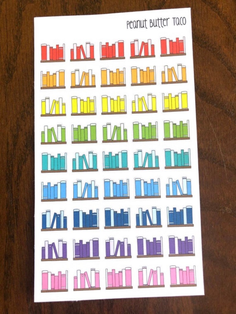 May include: A sheet of colorful book stack stickers with the text "Peanut Butter Taco" at the top. The stickers are arranged in a rainbow pattern, with red, orange, yellow, green, blue, purple, and pink book stacks.