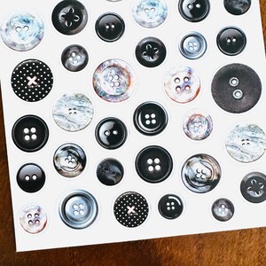 May include: A sheet of various black and white buttons. The buttons vary in size, shape, and design, including solid black, marbled, and polka dot patterns. Some buttons have two or four holes, while others have a shank.