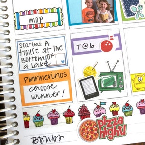 May include: A planner page with colorful stickers and handwritten notes. The stickers include a book, a bowling pin, a television, a cupcake, and a pizza slice. The handwritten notes include "Started: A house at the bottom of a lake", "Plannerinos", "choose winner!" and "T@b".