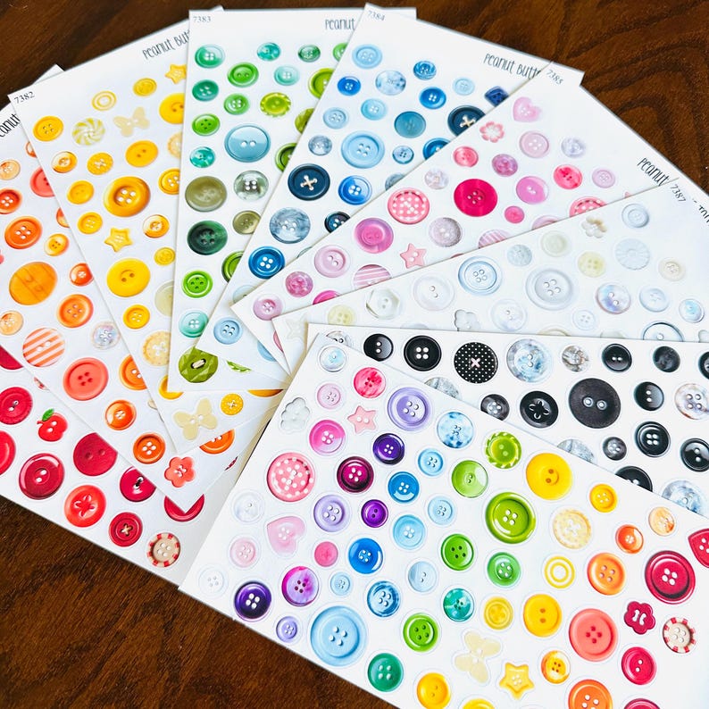 May include: A collection of sticker sheets featuring various colorful button designs. The stickers showcase a variety of colors, including red, orange, yellow, green, blue, and purple. Some stickers have a glossy finish, and some have a matte finish.