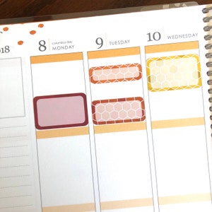 May include: A weekly planner with three columns labeled "Monday", "Tuesday", and "Wednesday". The dates "8", "9", and "10" are written above the columns. The planner has several decorative stickers with a honeycomb pattern in shades of brown, orange, and yellow.