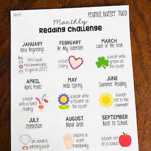 May include: A white paper sheet titled Monthly Reading Challenge by Peanut Butter Taco, featuring a grid of monthly reading prompts for 2027. Each month includes a theme and a small colorful icon, such as a heart, shamrock, flower, sun, trophy, and apple.