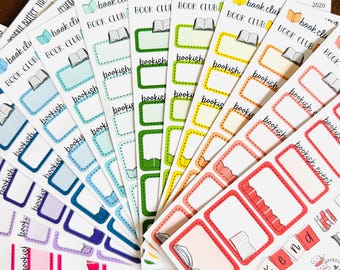 May include: A collection of colorful sticker sheets featuring various rectangular labels with rounded corners. Each sheet includes small book icons, the text "book club," "bookish," and "bookish event," arranged in a fan pattern with shades of red, orange, yellow, green, blue, and purple.